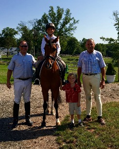 Two men, one boy on horse, and a little boy near horse
